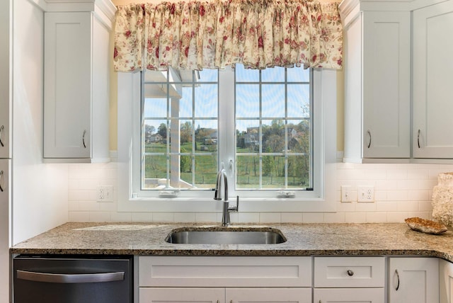 kitchen with dishwasher, stone counters, plenty of natural light, and a sink