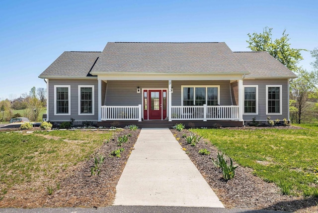 view of front of property featuring a front lawn, roof with shingles, and covered porch