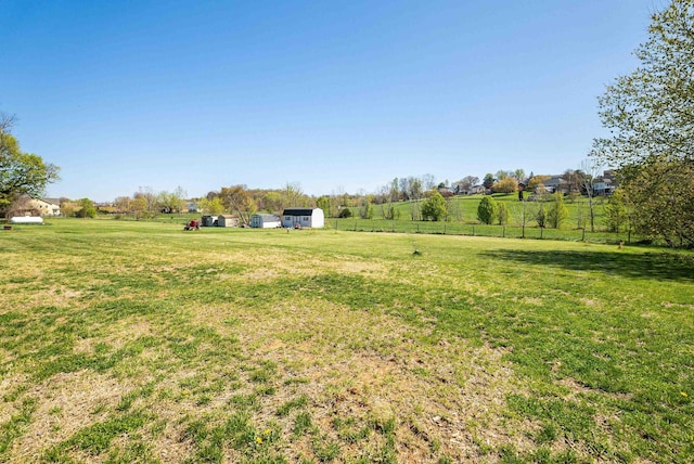 view of yard with a rural view and fence