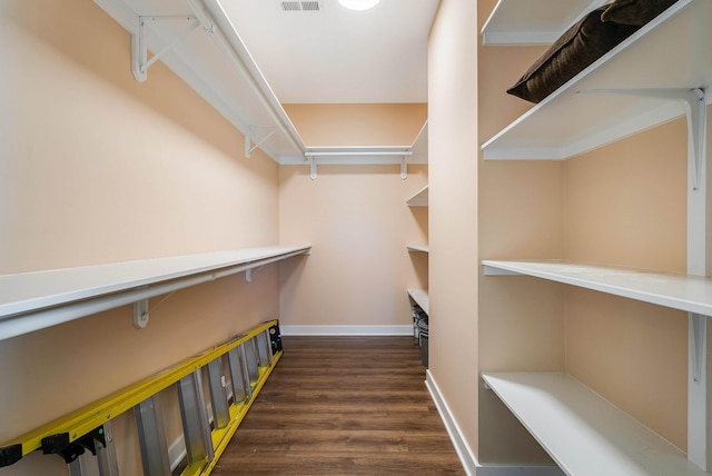 spacious closet with dark wood finished floors and visible vents