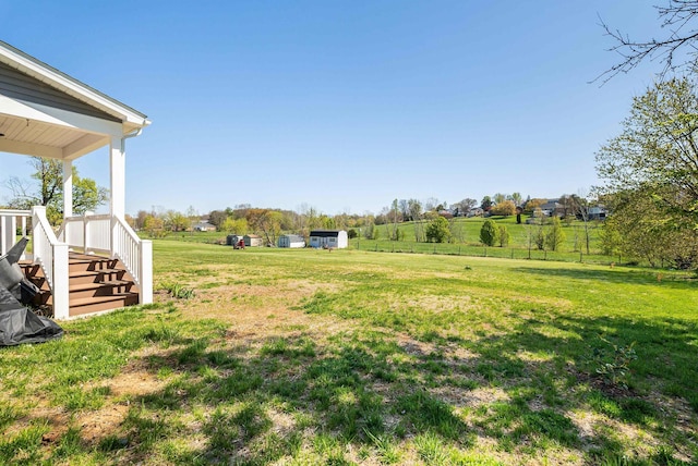 view of yard with covered porch and fence
