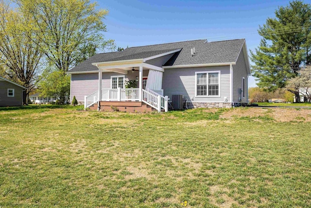 view of front of house with central air condition unit, a front lawn, roof with shingles, and a ceiling fan