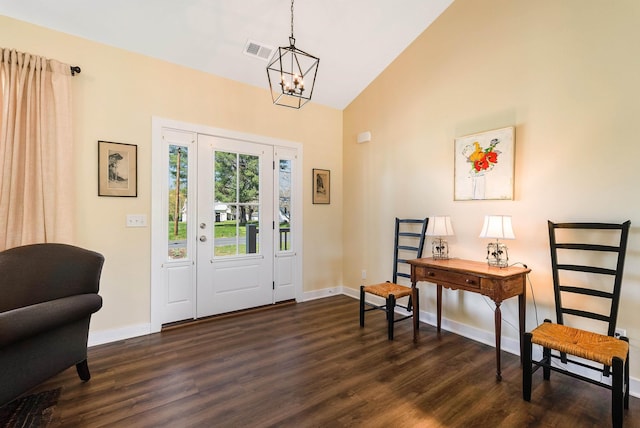 entryway with dark wood-style flooring, baseboards, visible vents, a notable chandelier, and high vaulted ceiling