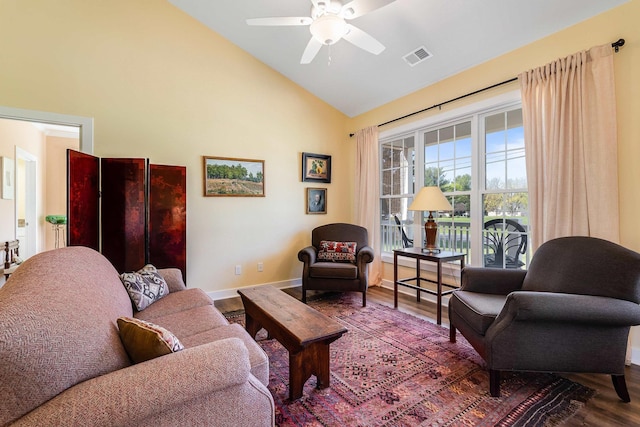 living room with wood finished floors, visible vents, a ceiling fan, baseboards, and high vaulted ceiling
