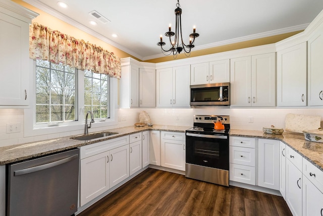 kitchen featuring white cabinets, stainless steel appliances, visible vents, ornamental molding, and a sink