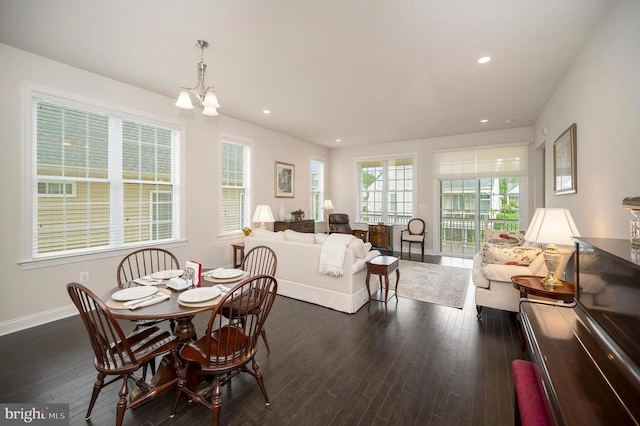 dining area with dark hardwood / wood-style flooring and a chandelier