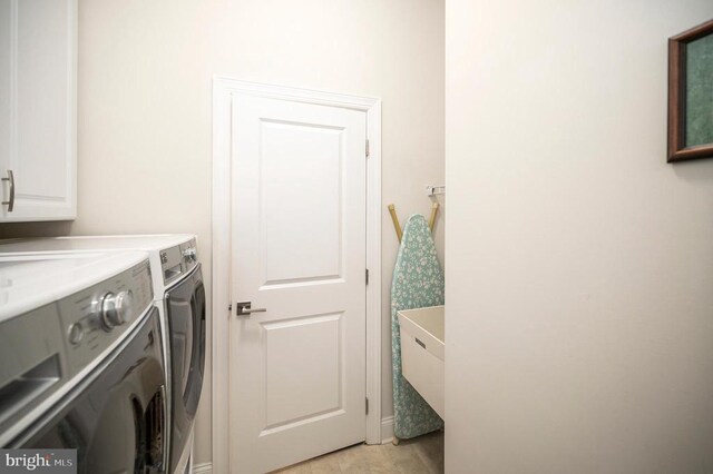 laundry room featuring washing machine and dryer and cabinets