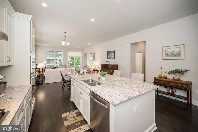 kitchen featuring sink, a kitchen island with sink, hanging light fixtures, white cabinetry, and stainless steel dishwasher