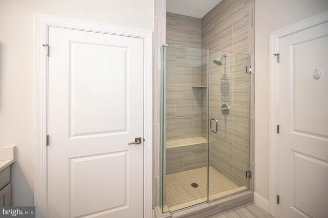 bathroom featuring vanity and an enclosed shower