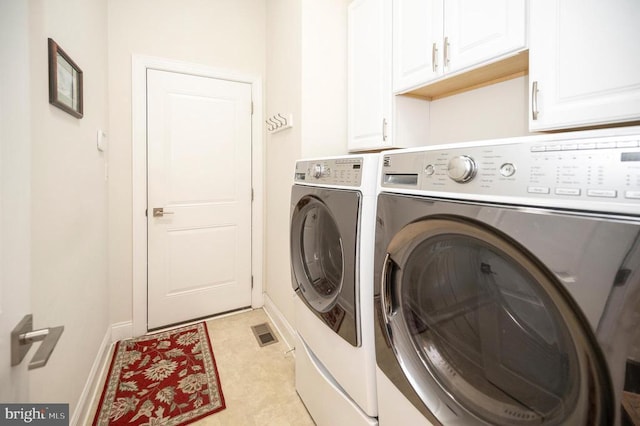 laundry room with cabinets and washer and clothes dryer