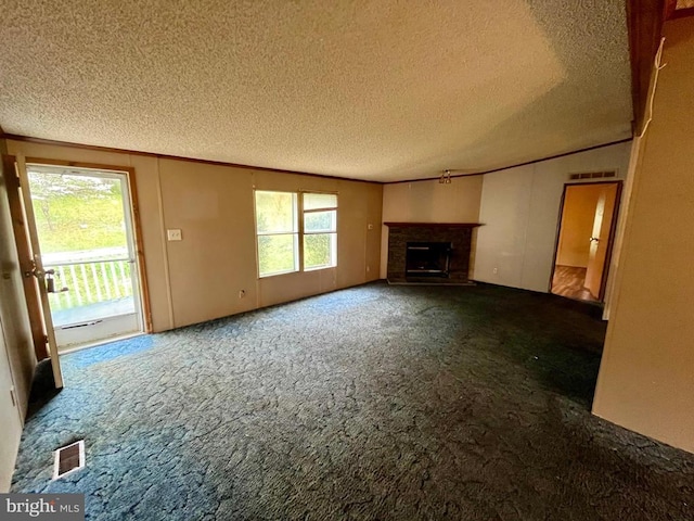 unfurnished living room with a fireplace with raised hearth, a textured ceiling, visible vents, and ornamental molding