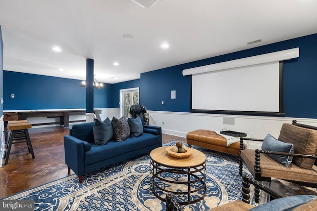 cinema with concrete flooring, a notable chandelier, recessed lighting, visible vents, and baseboards