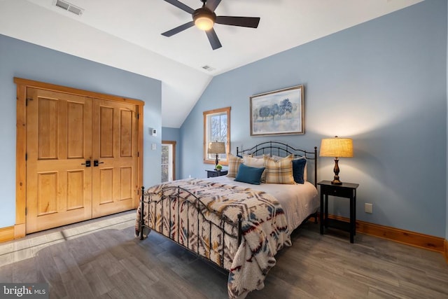 bedroom featuring vaulted ceiling, wood finished floors, visible vents, and baseboards