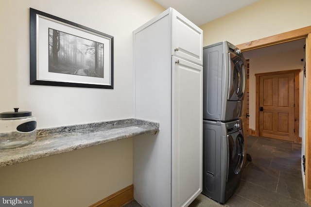 laundry room featuring cabinet space and stacked washer / drying machine