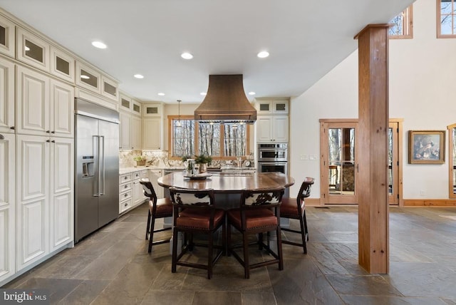 dining space with recessed lighting, baseboards, decorative columns, and stone tile floors