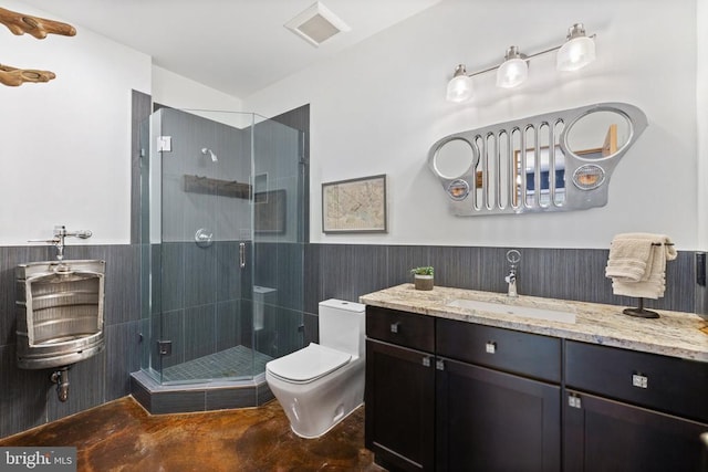 bathroom with a wainscoted wall, visible vents, toilet, a stall shower, and vanity