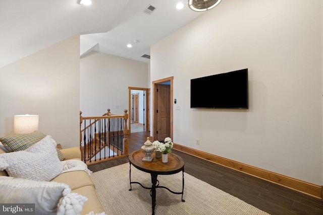 living room featuring baseboards, visible vents, lofted ceiling, wood finished floors, and recessed lighting