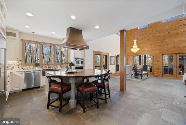 dining area with french doors, stone tile flooring, and wooden walls