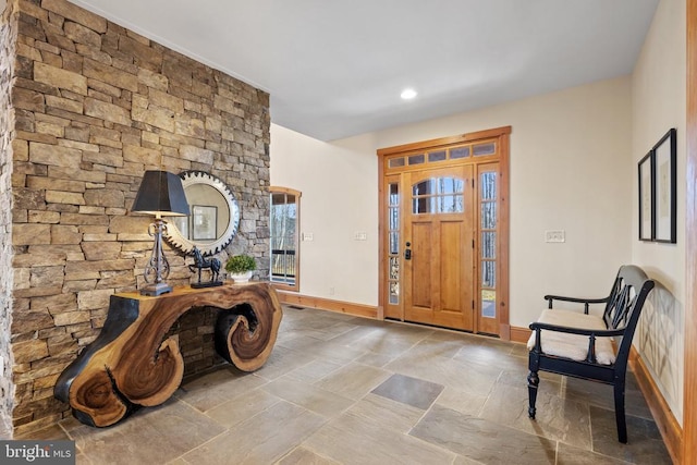 entrance foyer featuring stone finish floor and baseboards