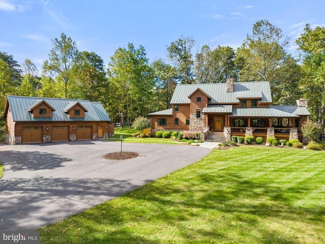 view of front of house featuring a garage, a standing seam roof, a chimney, and metal roof