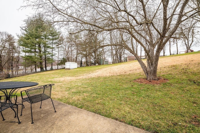 view of yard featuring a water view, a storage unit, and a patio