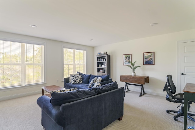 living area with light colored carpet and baseboards