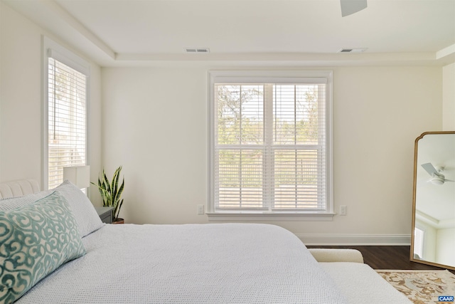 bedroom featuring multiple windows, wood finished floors, and visible vents