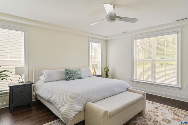 bedroom with baseboards, ceiling fan, dark wood-type flooring, and visible vents