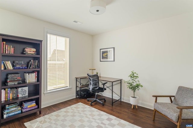 office space with baseboards, wood finished floors, and visible vents
