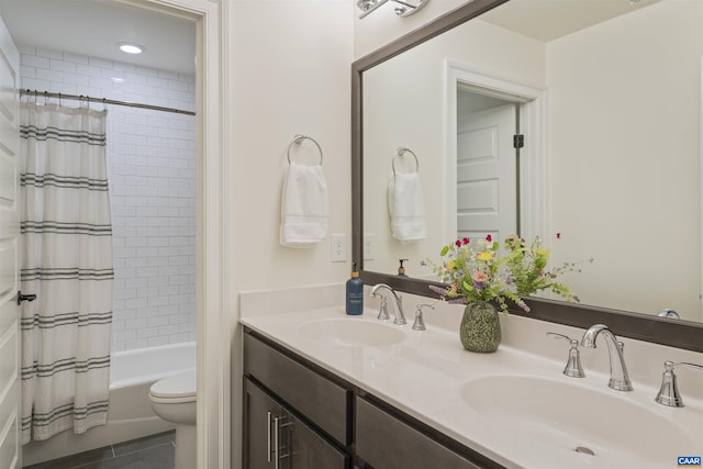 bathroom with double vanity, a sink, tile patterned floors, and shower / tub combo