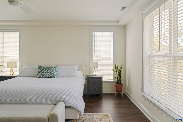 bedroom with visible vents, a ceiling fan, baseboards, and dark wood-style floors