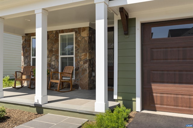 property entrance with covered porch and stone siding