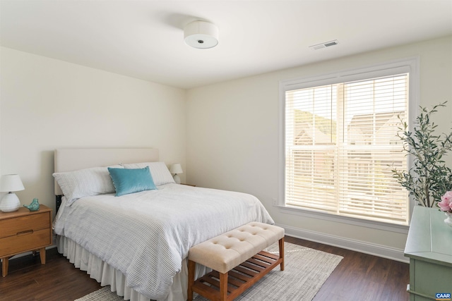 bedroom featuring visible vents, multiple windows, and dark wood finished floors