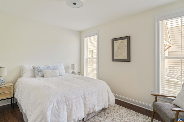 bedroom featuring baseboards and dark wood-type flooring