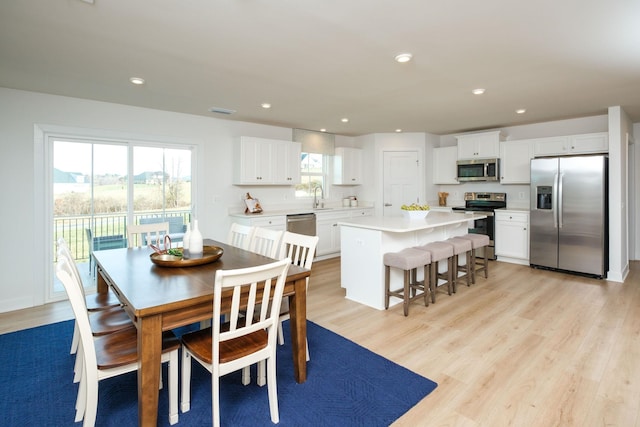 dining area featuring sink and light hardwood / wood-style flooring