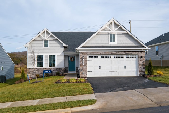 craftsman house with a garage, a front yard, and cooling unit