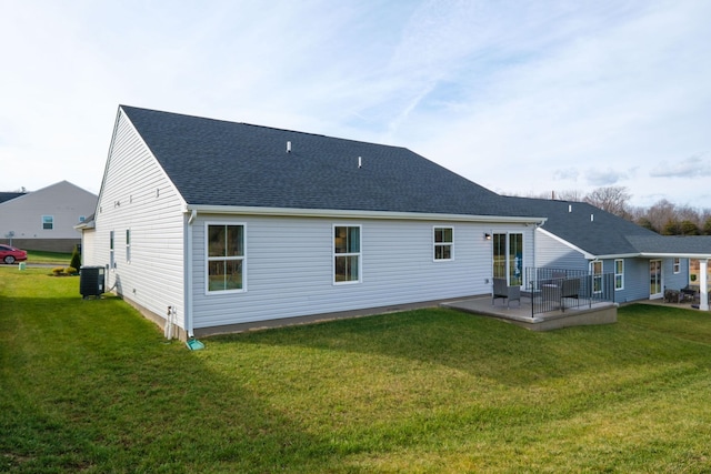 rear view of property with central AC unit, a patio area, and a lawn