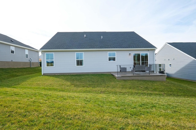 rear view of house featuring a yard and a deck