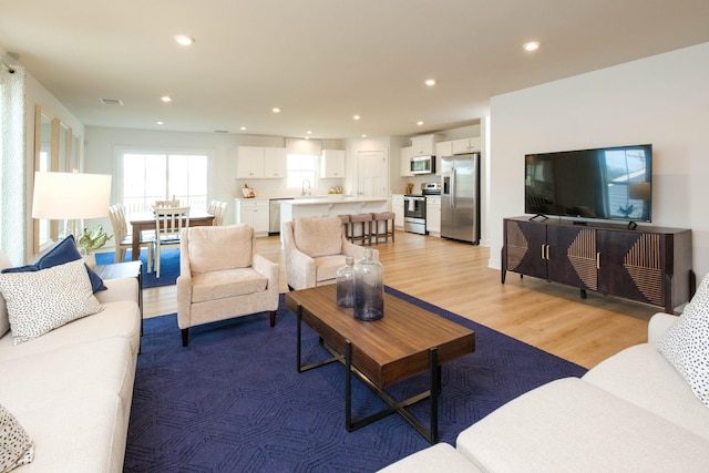 living room with sink and light hardwood / wood-style floors