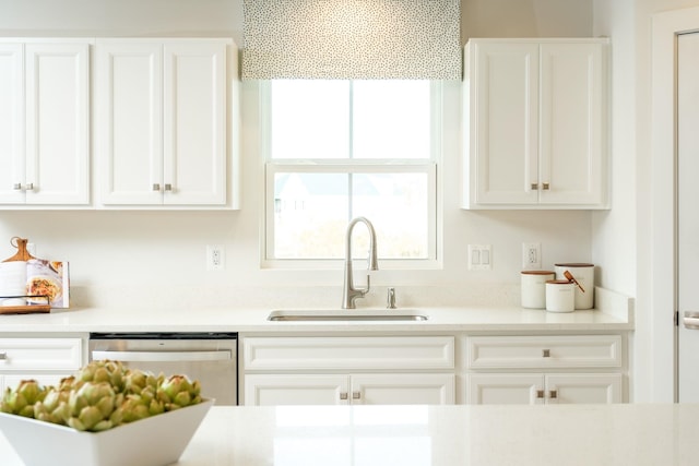 kitchen featuring stainless steel dishwasher, sink, and white cabinets