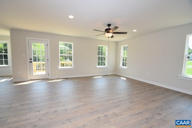 empty room with ceiling fan and light hardwood / wood-style floors