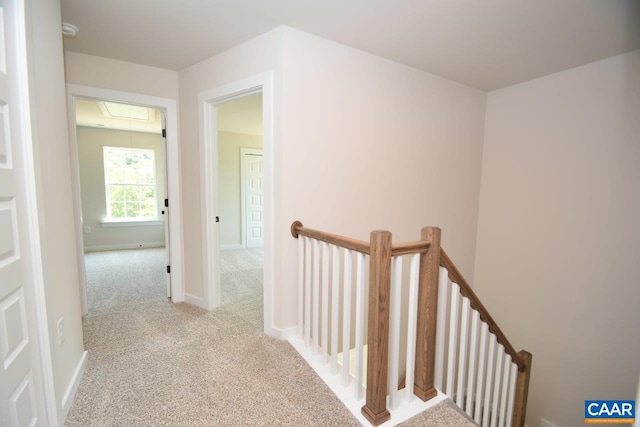 hallway featuring light colored carpet