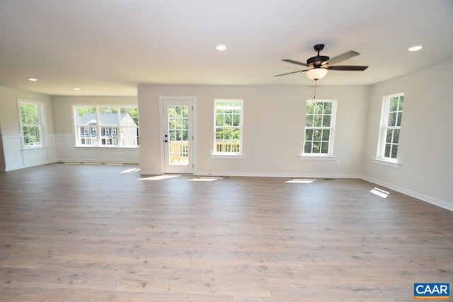 unfurnished living room featuring ceiling fan, light hardwood / wood-style floors, and a healthy amount of sunlight