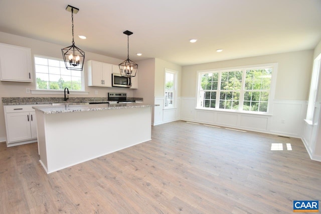 kitchen featuring stainless steel appliances, white cabinets, and a kitchen island