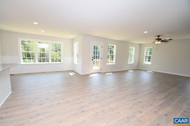 unfurnished living room with ceiling fan and light hardwood / wood-style flooring