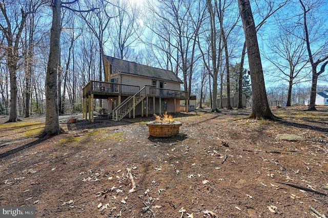 exterior space with a deck, stairway, and a fire pit