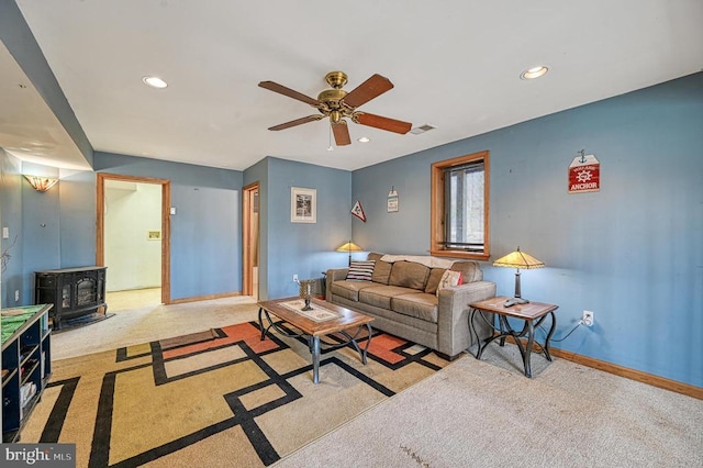 carpeted living area with ceiling fan, recessed lighting, visible vents, baseboards, and a wood stove