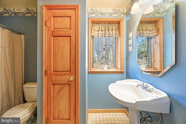 full bath with baseboards, toilet, and tile patterned floors