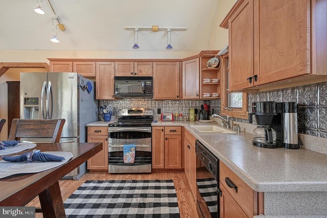 kitchen featuring light wood finished floors, open shelves, tasteful backsplash, a sink, and black appliances