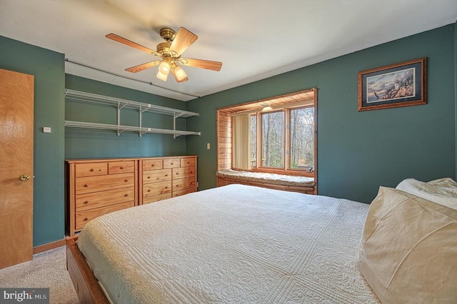 carpeted bedroom with ceiling fan and baseboards